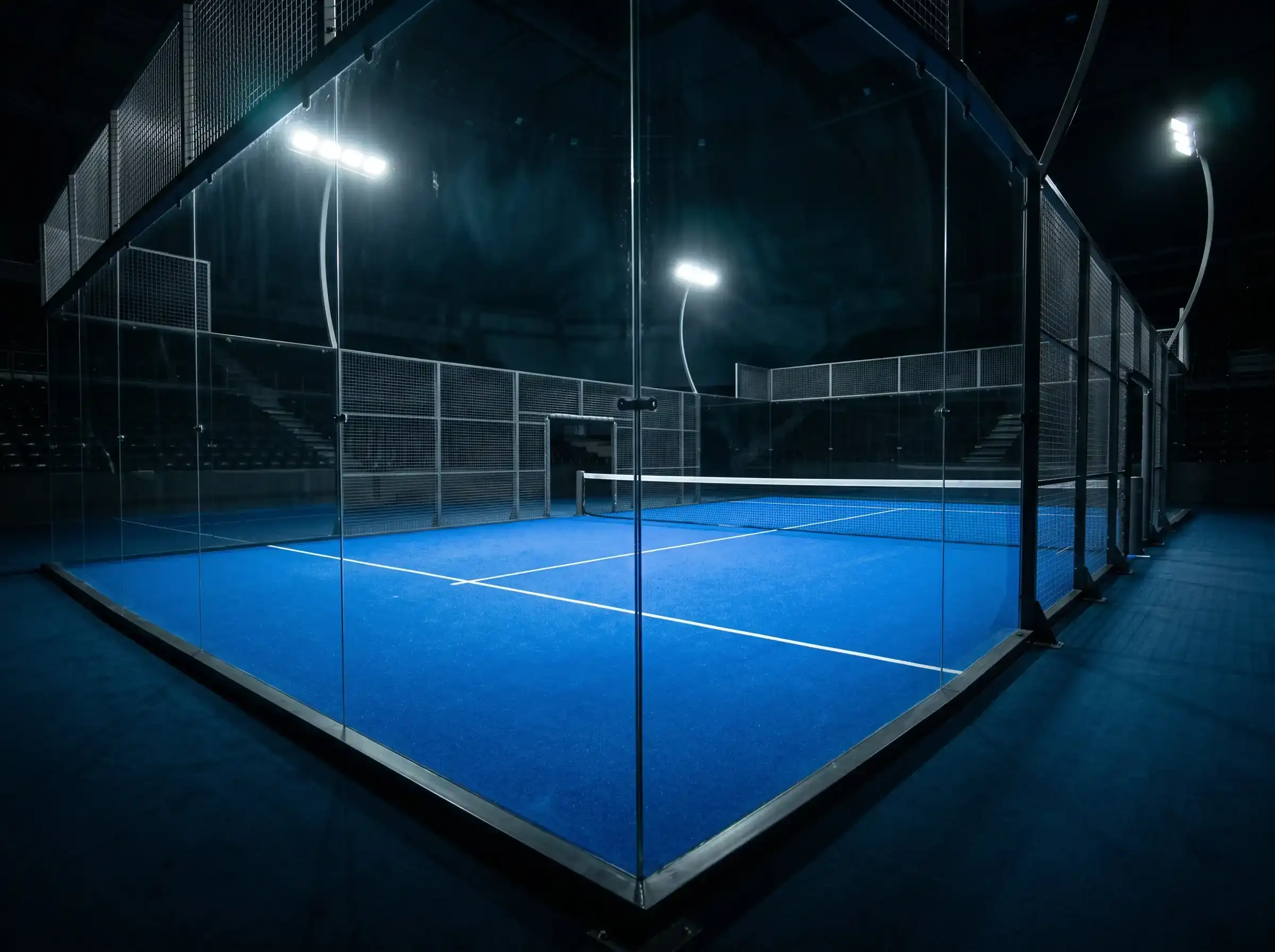 Pista central de Premier Padel con paredes de cristal iluminada para una final del circuito
